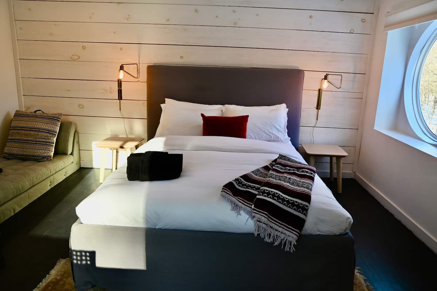 Bedroom with a porthole window overlooking the trees