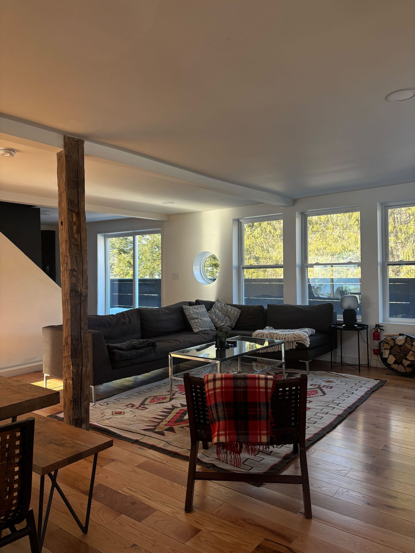 The living room with its porthole window and forest views