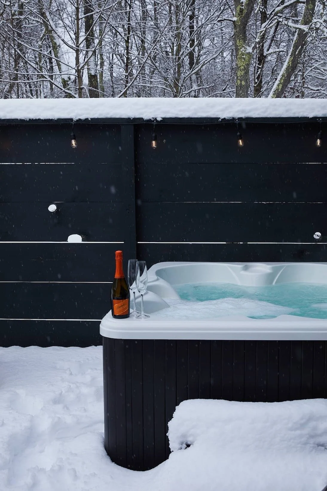 Year-round outdoor hot tub at Black Bear Cottage overlooking the forest